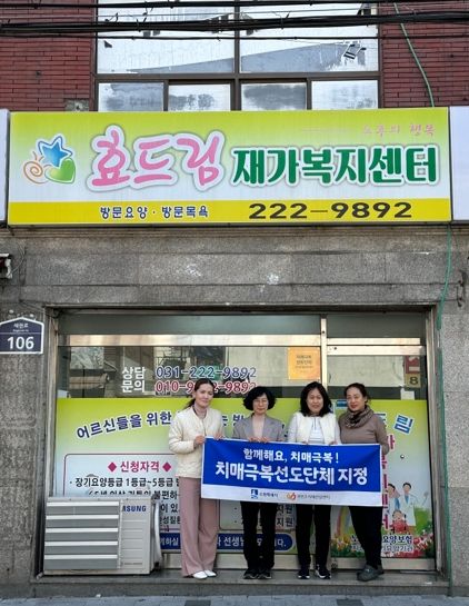 치매극복선도단체로 지정한 효드림재가복지센터에 현판을 전달하는 모습.