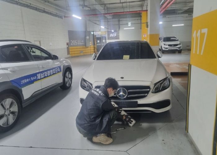 담당 공무원이 체납 차량의 번호판 영치를 실시하고 있다.