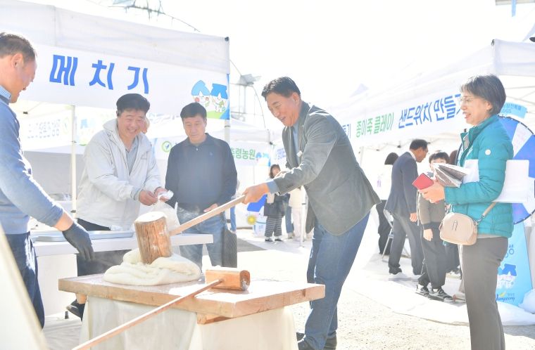 지난 15일 황룡면 팜파티 현장을 방문한 김한종 장성군수가 떡메치기 체험을 하고 있다.