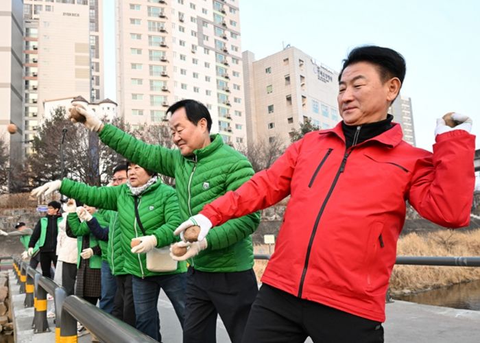 2월 21일 의정부시 새마을회(회장 조상권)가 경전철 동오역 인근에서 수질 개선을 위한 EM 흙공 던지기 활동을 실시하고 있다.