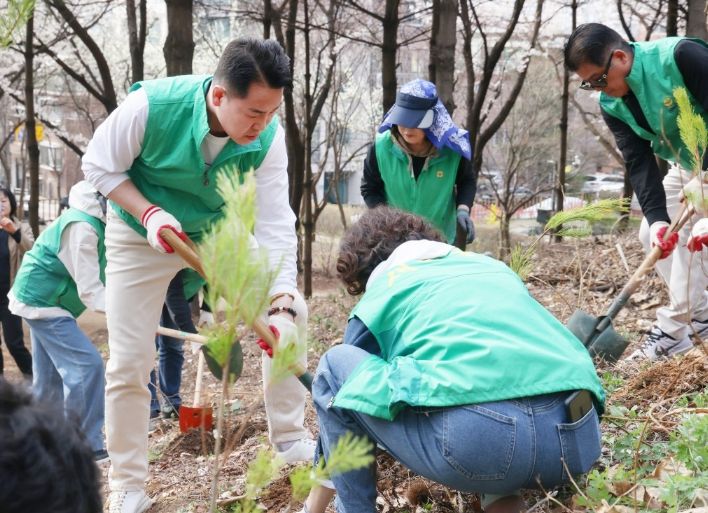 오언석 도봉구청장이 지난 4월 3일 새마을운동 도봉구지회와 함께 초안산 근린공원에서 나무를 심고 있다